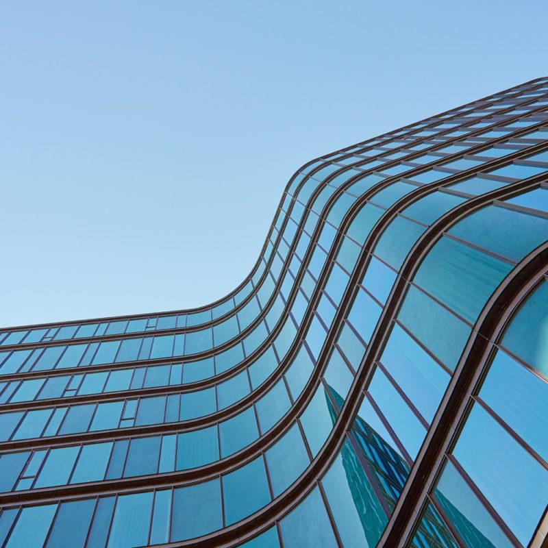 Modern,Building,With,Curved,Glass,Facade,Reflecting,Sky ,Contemporary,Architectural